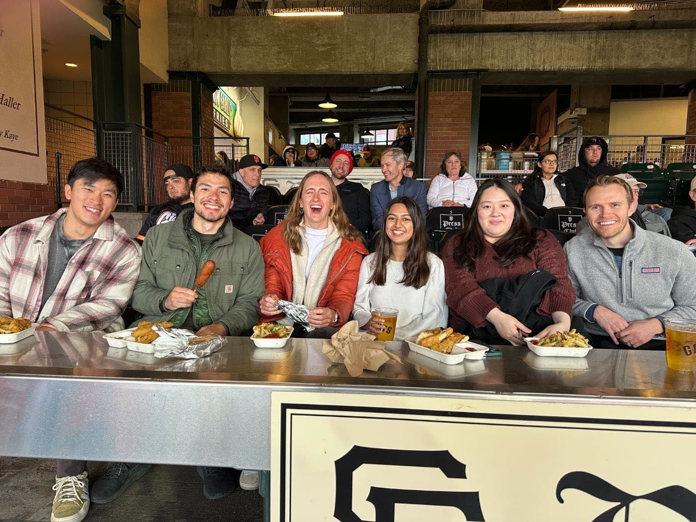 Teammates in the stands with ballpark food at a Giants game