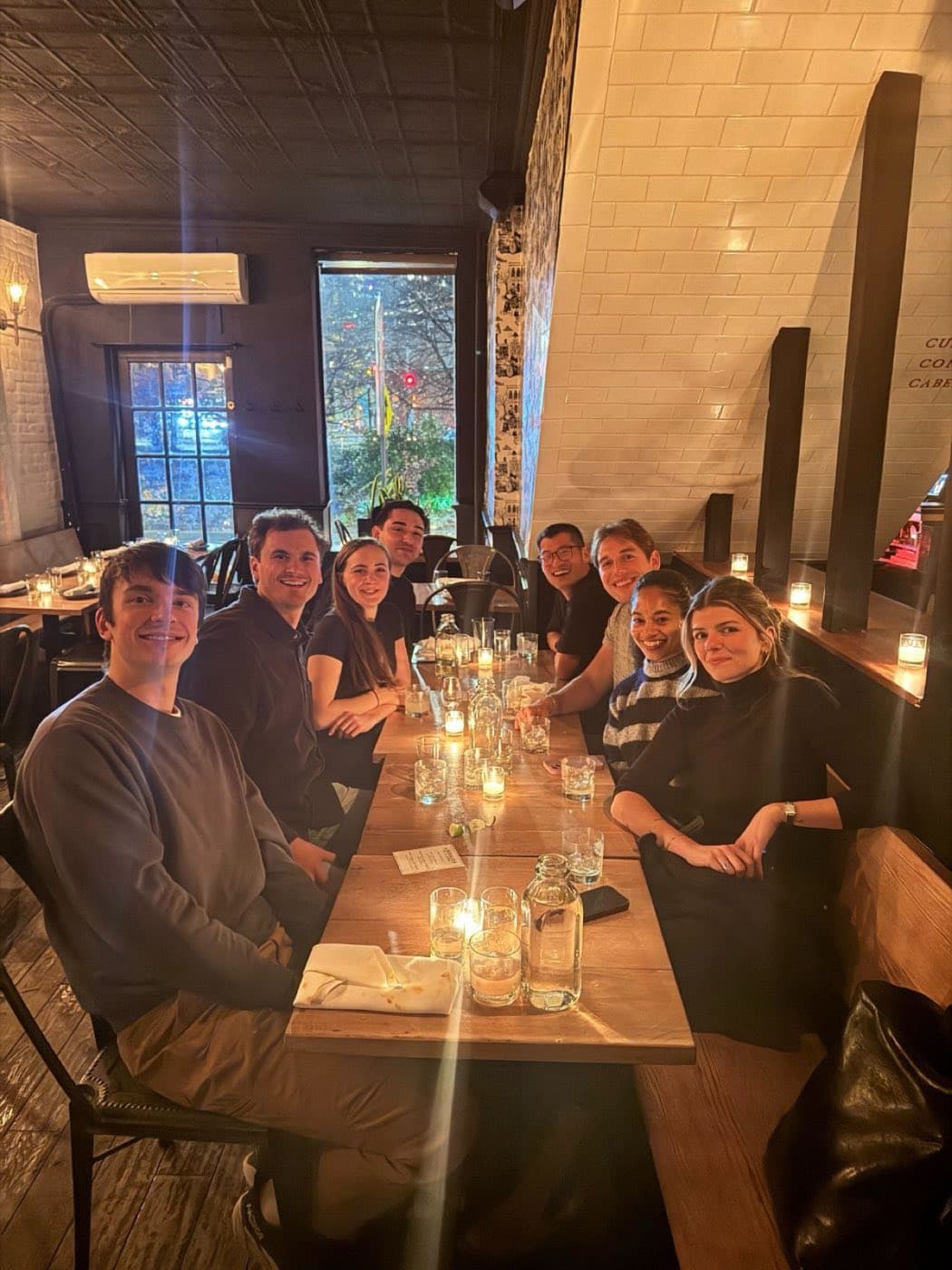 Teammates at a long candlelit table for a team dinner