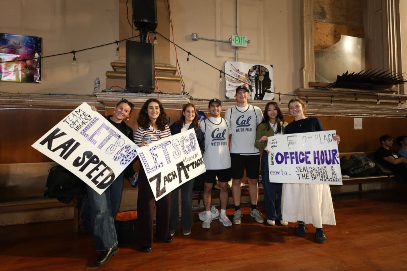 Teammates holding hand-made signs at a company tournament